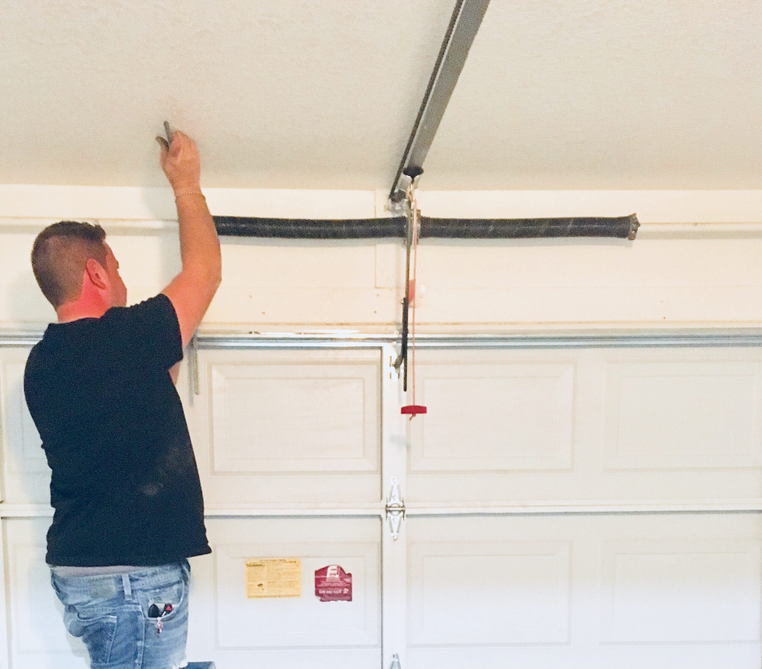 Garage door spring replacement and torsion spring repair service in Phoenix AZ with professional technician servicing residential overhead garage doors.