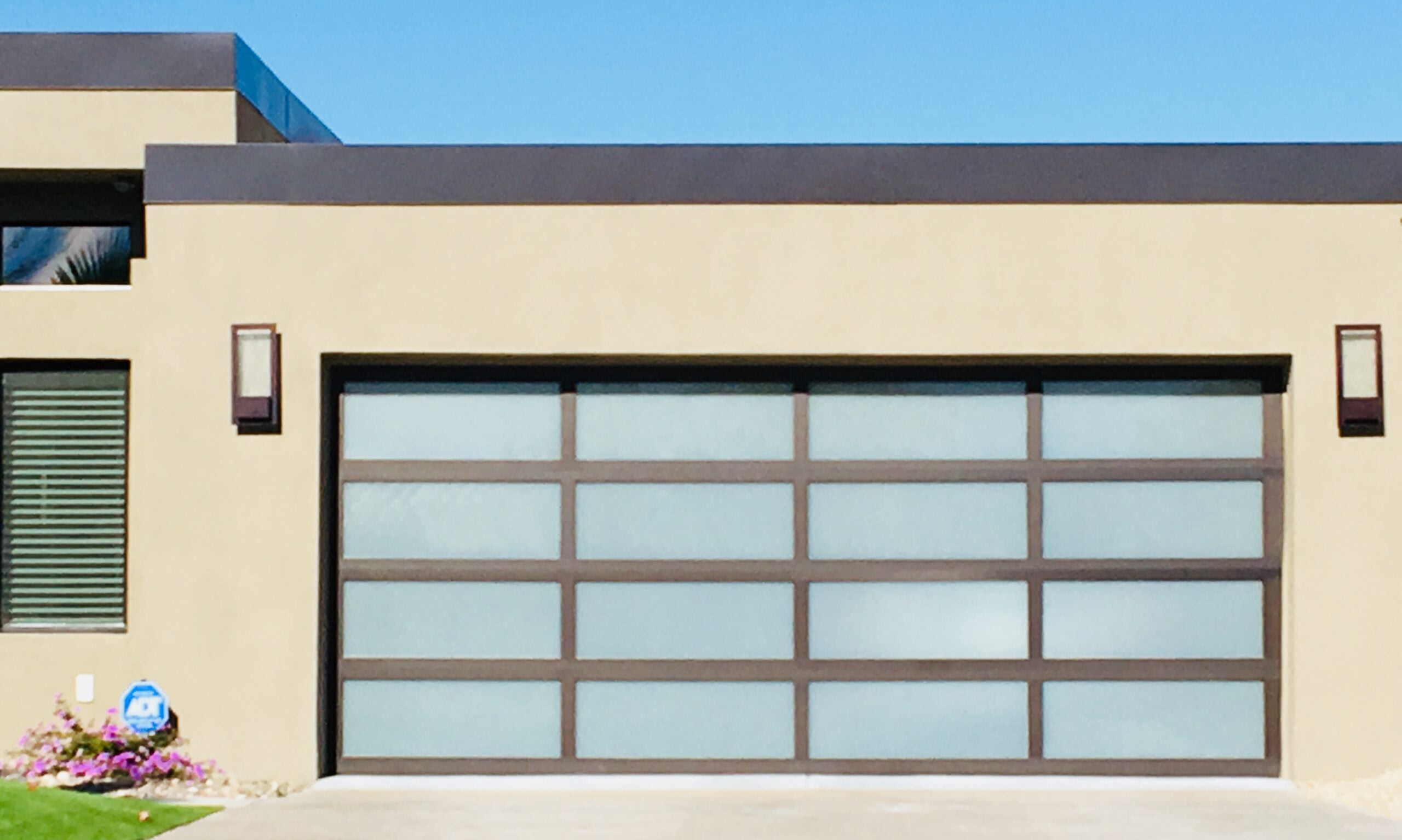 Contemporary full-view glass garage door installation in Phoenix AZ featuring modern aluminum frame garage doors for luxury residential homes.